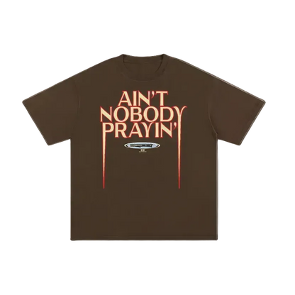 Brown t-shirt with red text 'Ain't Nobody Prayin'' on a white background
