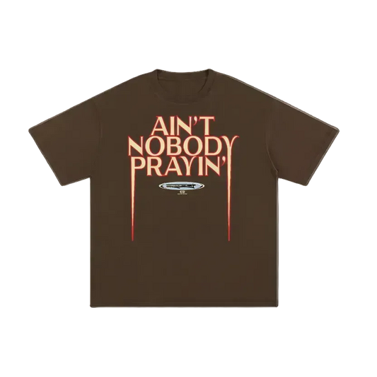 Brown t-shirt with red text 'Ain't Nobody Prayin'' on a white background
